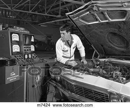 1960S Auto Automobile Mechanic Testing Engine Electronics Under Hood Car Tune Up Check Repair View Large Photo Image Picture - 1960S Auto Automobile Mechanic Testing Engine Electronics Under Hood Car Tune Up Check Repair . Fotosearch