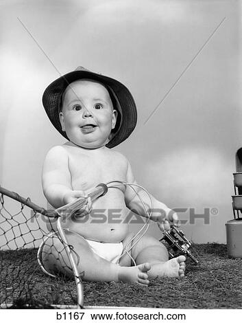 1960S Baby Girl Wearing Fishing Hat Holding Net And Reel Fishing Gear Indoor View Large Photo Image Stock Photo - 1960S Baby Girl Wearing Fishing Hat Holding Net And Reel Fishing Gear Indoor . Fotosearch