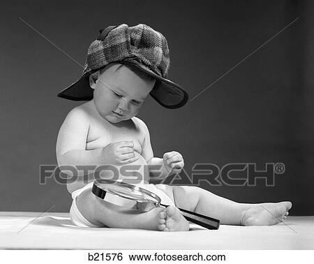 Stock Photograph - 1960S Baby In Diaper & Sherlock Holmes Style Double-Billed Cap With Magnifying Glass Resting On Leg Looking Downward . Fotosearch