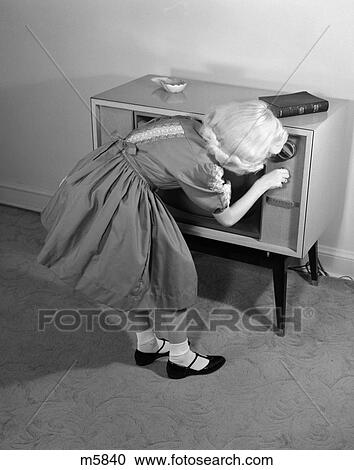 Stock Image -  1960S Blond Girl Turning On Tv Bible And Ash Tray On Top. Fotosearch