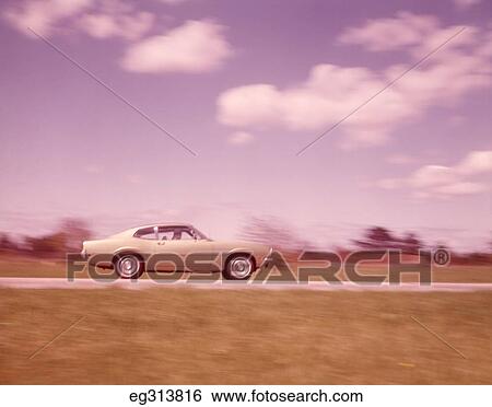 Stock Photograph - 1960S Blurred Motion Shot Car On Road. Fotosearch