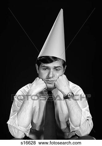 Stock Photo - 1960S Business Man Shirt Tie Dunce Cap Character Expression Stupid Error Silly Punishment Cone Triangle . Fotosearch