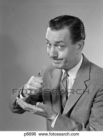 1960S Businessman Determined Serious Expression Pounding Fist Into Palm Of His Hand View Large Photo Image Stock Photograph - 1960S Businessman Determined Serious Expression Pounding Fist Into Palm Of His Hand . Fotosearch