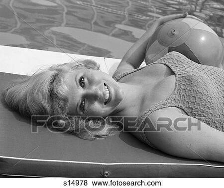 1960S Close-Up Of Blonde Bathing Beauty Lying Flat On Back On Raft In Pool With Beach Ball Under Arm Turning Head Toward Camera View Large Photo Image Stock Photo - 1960S Close-Up Of Blonde Bathing Beauty Lying Flat On Back On Raft In Pool With Beach Ball Under Arm Turning Head Toward Camera. Fotosearch