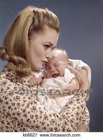1960S Close-Up Of Mother Holding Crying Baby Infant Woman Fussing Profile Cuddling View Large Photo Image Stock Photo - 1960S Close-Up Of Mother Holding Crying Baby Infant Woman Fussing Profile Cuddling. Fotosearch