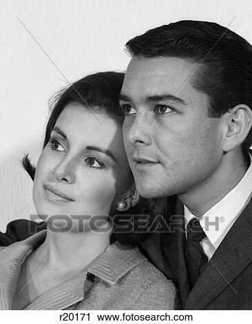 Stock Image - 1960S Close-Up Portrait Of Couple Looking Off To Side Man With Arm Around Woman . Fotosearch
