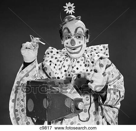 1960S Clown In Polka-Dotted Outfit Taking Picture With Old-Time Camera Holding Birdie In Opposite Hand View Large Photo Image Stock Photo - 1960S Clown In Polka-Dotted Outfit Taking Picture With Old-Time Camera Holding Birdie In Opposite Hand. Fotosearch
