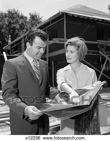 1960S Couple At Home Construction Site Looking Over Blueprints View Large Photo Image Stock Photograph - 1960S Couple At Home Construction Site Looking Over Blueprints . Fotosearch