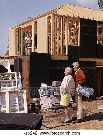 1960S Couple Looking At New Home Under Construction Building Man Woman Outdoor View Large Photo Image Stock Image - 1960S Couple Looking At New Home Under Construction Building Man Woman Outdoor. Fotosearch