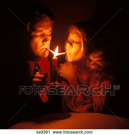 1960S Couple Man Woman Light Cigarettes From Flame Of Candle Cigarette Tobacco Lighting Puff Puffing Suck Habit Addict View Large Photo Image Stock Image - 1960S Couple Man Woman Light Cigarettes From Flame Of Candle Cigarette Tobacco Lighting Puff Puffing Suck Habit Addict. Fotosearch