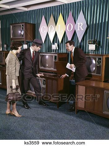 1960S Couple With Salesman Looking At Color Televisions In Department Store Man Woman Indoor View Large Photo Image Stock Photo - 1960S Couple With Salesman Looking At Color Televisions In Department Store Man Woman Indoor. Fotosearch