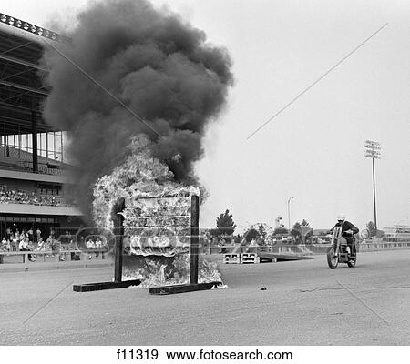 Stock Photo - 1960S Daredevil On Motorcycle Approaching Wall Of Fire . Fotosearch