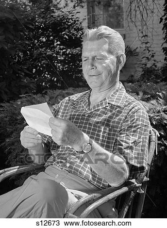 1960S Elderly Man Sitting In Rattan Chair In Backyard Reading Letter View Large Photo Image Stock Image - 1960S Elderly Man Sitting In Rattan Chair In Backyard Reading Letter . Fotosearch