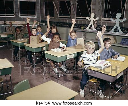 1960S Elementary School Children In Classroom With Hands Raised To Answer Question View Large Photo Image Picture - 1960S Elementary School Children In Classroom With Hands Raised To Answer Question. Fotosearch