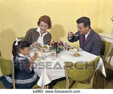 1960S Family Enjoying Dinner Together At Table Indoor Man Woman Girl View Large Photo Image Stock Photography - 1960S Family Enjoying Dinner Together At Table Indoor Man Woman Girl . Fotosearch