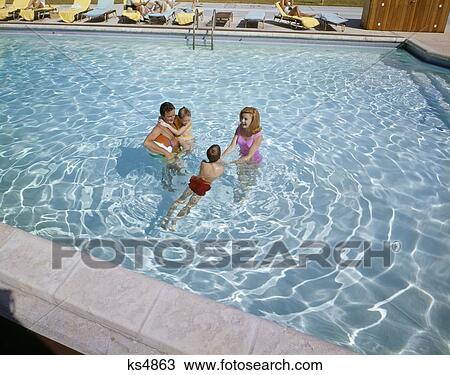 Stock Image - 1960S Family Father Mother Son Daughter Swimming Together In Motel Swimming Pool Happy Clear Water. Fotosearch