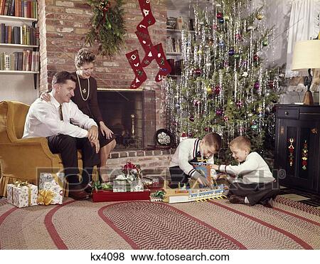 1960S Family In Living Room Christmas Tree Boys Playing With Toys Mother Father Sitting In Chair View Large Photo Image Stock Photo - 1960S Family In Living Room Christmas Tree Boys Playing With Toys Mother Father Sitting In Chair . Fotosearch