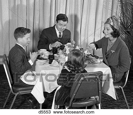 1960S Family Of 4 Seated At Table In Formal Attire Eating Dinner & Having Conversation View Large Photo Image Stock Image - 1960S Family Of 4 Seated At Table In Formal Attire Eating Dinner & Having Conversation . Fotosearch