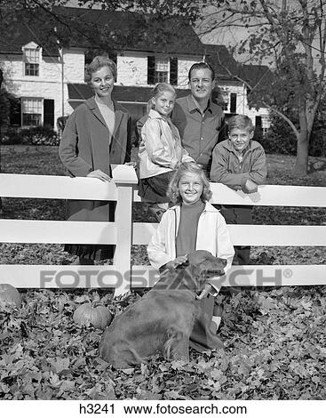 1960S Family Of 5 & Dog Gathered Around White Fence In Front Yard With Fallen Leaves & Pumpkins View Large Photo Image Stock Image - 1960S Family Of 5 & Dog Gathered Around White Fence In Front Yard With Fallen Leaves & Pumpkins . Fotosearch