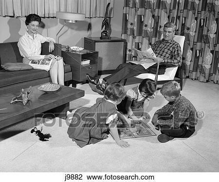 1960S Family Of 5 Living Room Mother On Couch Father In Chair Watch Kids 2 Girls And 1 Boy Playing Board Game On Floor View Large Photo Image Stock Image - 1960S Family Of 5 Living Room Mother On Couch Father In Chair Watch Kids 2 Girls And 1 Boy Playing Board Game On Floor . Fotosearch