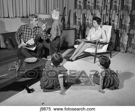 1960S Family Of Four In Living Room Boy Son Is Being Disciplined By Dad Shaking Finger View Large Photo Image Stock Photography - 1960S Family Of Four In Living Room Boy Son Is Being Disciplined By Dad Shaking Finger. Fotosearch