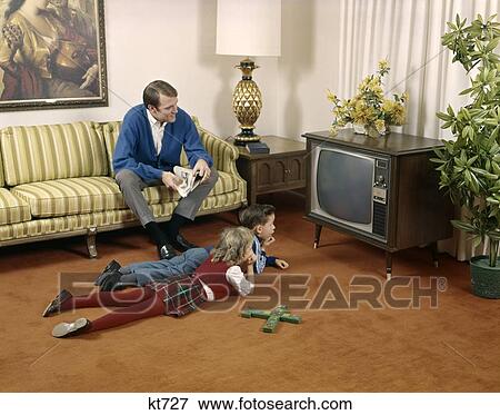 1960'S Father Sitting On Living Room Couch Brother And Sister On Floor Watch Television Family Man Boy Girl Indoor View Large Photo Image Stock Photo - 1960'S Father Sitting On Living Room Couch Brother And Sister On Floor Watch Television Family Man Boy Girl Indoor. Fotosearch