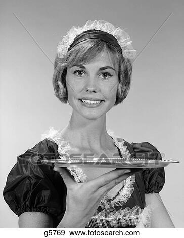 1960S Girl In Waitress Uniform With Matching Lace Headpiece Smiling While Holding Up An Empty Serving Tray View Large Photo Image Stock Photo - 1960S Girl In Waitress Uniform With Matching Lace Headpiece Smiling While Holding Up An Empty Serving Tray . Fotosearch