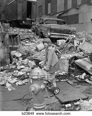 1960S Girl Standing On Back Of Tricycle Behind Open Fire Hydrant Surrounded By Wreckage With Old Beat-Up Car In Background View Large Photo Image Stock Photo - 1960S Girl Standing On Back Of Tricycle Behind Open Fire Hydrant Surrounded By Wreckage With Old Beat-Up Car In Background. Fotosearch
