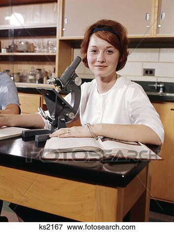 1960S Girl Student Laboratory Lab Class Biology Chemistry Sitting At Microscope With Open Book Smiling High School Teen View Large Photo Image Stock Photo - 1960S Girl Student Laboratory Lab Class Biology Chemistry Sitting At Microscope With Open Book Smiling High School Teen. Fotosearch