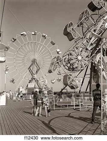 1960S Group Of Teens Looking At Amusement Rides On Pier View Large Photo Image Stock Image - 1960S Group Of Teens Looking At Amusement Rides On Pier . Fotosearch