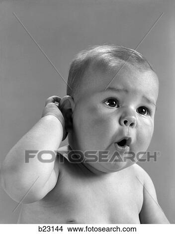 1960S Head Shot Of Baby With Hand To One Ear And Mouth Open Indoor View Large Photo Image Picture - 1960S Head Shot Of Baby With Hand To One Ear And Mouth Open Indoor . Fotosearch