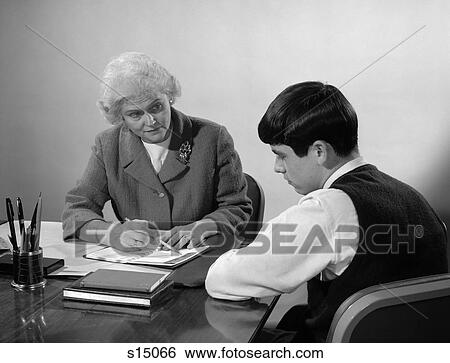 1960S High School Student Sitting At Desk Going Over Plans With Guidance Counselor View Large Photo Image Stock Photograph - 1960S High School Student Sitting At Desk Going Over Plans With Guidance Counselor . Fotosearch