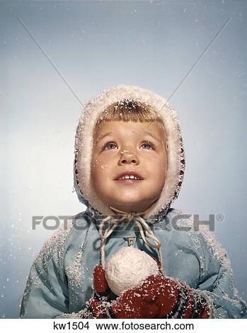 1960'S Little Girl Holding Snow Ball Looking Up At Sky Hopefully Red Mittens White Knit Hat Blue Coat View Large Photo Image Picture - 1960'S Little Girl Holding Snow Ball Looking Up At Sky Hopefully Red Mittens White Knit Hat Blue Coat. Fotosearch