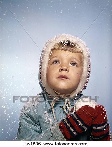 Stock Photograph - 1960'S Little Girl Holding Snow Ball Looking Sad Up At The Sky Red Mittens White Knit Hat Blue Jacket Retro. Fotosearch