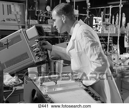 Stock Image -  1960S Male Laboratory Technician Dressed In A White Lab Coat Reading A Oscillascope . Fotosearch