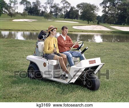 1960S Man And Woman In Golf Cart Driving Across Grass Near Water Couple Hobby Lifestyle Golf Clubs Bag View Large Photo Image Stock Photo - 1960S Man And Woman In Golf Cart Driving Across Grass Near Water Couple Hobby Lifestyle Golf Clubs Bag. Fotosearch