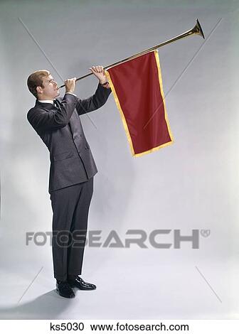 Stock Image - 1960S Man Blowing Pageant Type Trumpet With Pennant Flag Announcement Event Occasion One. Fotosearch