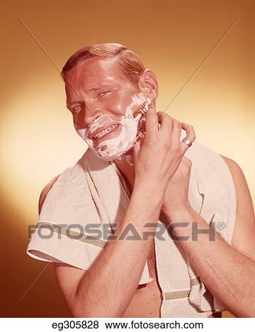 1960S Man Looking As If In Bathroom Mirror Shaving Face With Razor Towel Around Neck View Large Photo Image Stock Photo - 1960S Man Looking As If In Bathroom Mirror Shaving Face With Razor Towel Around Neck. Fotosearch