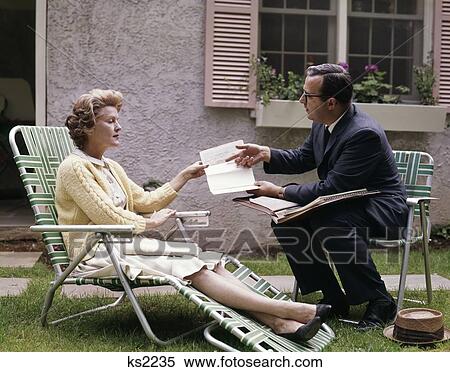 1960S Man Showing Material In Papers To Woman Sitting Outside Suburban House Insurance Medical Salesman View Large Photo Image Stock Photography - 1960S Man Showing Material In Papers To Woman Sitting Outside Suburban House Insurance Medical Salesman. Fotosearch