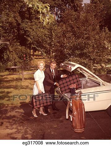 1960S Middle Aged Couple Putting Luggage In Car Trunk View Large Photo Image Stock Photo - 1960S Middle Aged Couple Putting Luggage In Car Trunk. Fotosearch
