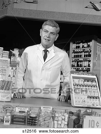 1960S Pharmacist Standing At Counter Facing Camera Drug Cosmetics Sales Customer Service Lab Coat Pharmacy Store Retro Vintage View Large Photo Image Stock Photograph - 1960S Pharmacist Standing At Counter Facing Camera Drug Cosmetics Sales Customer Service Lab Coat Pharmacy Store Retro Vintage. Fotosearch