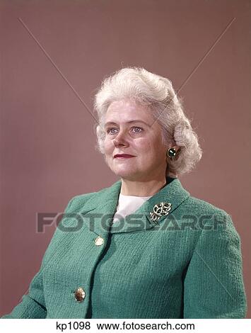 1960S Portrait Half Smiling Senior Woman Beige Background Gray Silver Hair Wear Green Knit Jacket Gold Buttons Brooch View Large Photo Image Stock Photo - 1960S Portrait Half Smiling Senior Woman Beige Background Gray Silver Hair Wear Green Knit Jacket Gold Buttons Brooch . Fotosearch