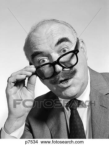 1960S Portrait Of Balding Elderly Man In Suit With Bushy Mustache Pulling Thick Black Glasses Down On Nose To Look Over Them View Large Photo Image Picture - 1960S Portrait Of Balding Elderly Man In Suit With Bushy Mustache Pulling Thick Black Glasses Down On Nose To Look Over Them. Fotosearch