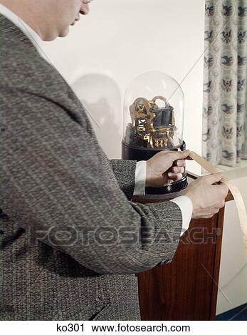 1960S Retro Man Reading Ticker Tape In Office Standing By Antique Ticker Tape Machine With Glass Dome View Large Photo Image Stock Image - 1960S Retro Man Reading Ticker Tape In Office Standing By Antique Ticker Tape Machine With Glass Dome. Fotosearch