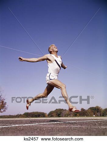1960S Runner At Finish Line Breaking Through Tape View Large Photo Image Stock Photo - 1960S Runner At Finish Line Breaking Through Tape . Fotosearch