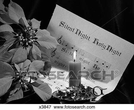 1960S Sheet Music Of Silent Night Lighted By Candle In Holder Decorated With Holly Sitting Next To Poinsettia View Large Photo Image Stock Photo - 1960S Sheet Music Of Silent Night Lighted By Candle In Holder Decorated With Holly Sitting Next To Poinsettia . Fotosearch