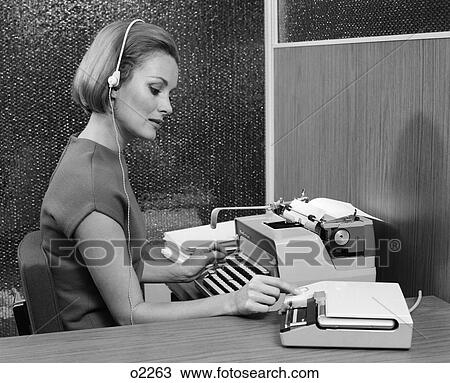 1960S Side View Of Secretary At Desk Behind Typewriter Wearing Headset & Turning Knob On Dictaphone View Large Photo Image Stock Image - 1960S Side View Of Secretary At Desk Behind Typewriter Wearing Headset & Turning Knob On Dictaphone . Fotosearch