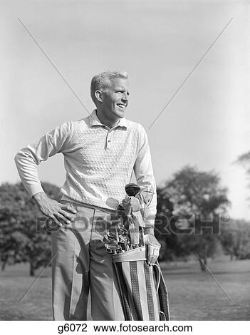 1960S Smiling Blonde Man Handsome Stand With Golf Bag Cubs Irons Looking Down Fairway Of Golf Course Athlete View Large Photo Image Stock Image - 1960S Smiling Blonde Man Handsome Stand With Golf Bag Cubs Irons Looking Down Fairway Of Golf Course Athlete . Fotosearch