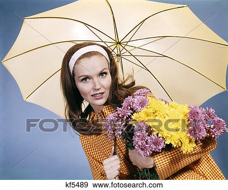 1960S Smiling Brunette Woman Holding Bouquet Autumn Flowers Chrysanthemums Under Umbrella Red Yellow Rain Coat View Large Photo Image Stock Photo - 1960S Smiling Brunette Woman Holding Bouquet Autumn Flowers Chrysanthemums Under Umbrella Red Yellow Rain Coat . Fotosearch