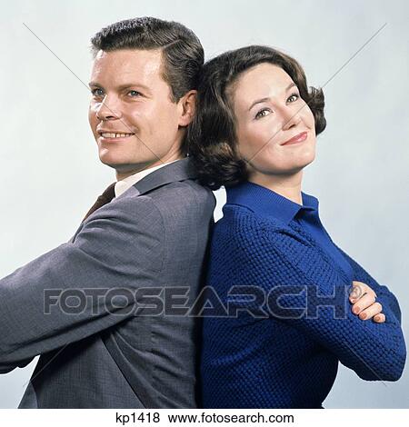 1960S Smiling Man And Woman Standing Back To Back With Arms Folded Studio Symbolic View Large Photo Image Stock Photo - 1960S Smiling Man And Woman Standing Back To Back With Arms Folded Studio Symbolic. Fotosearch